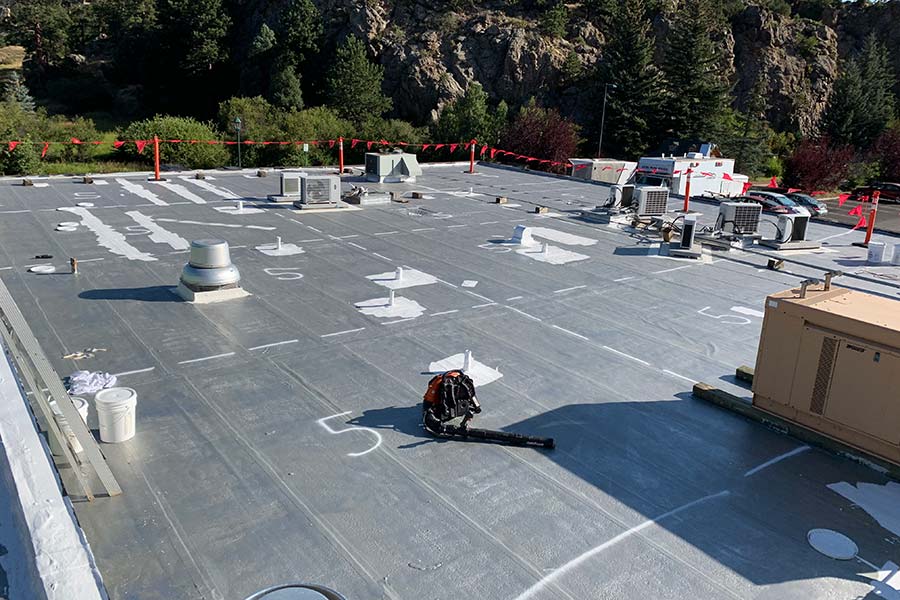 Roof coating application in progress — Police station (municipal)