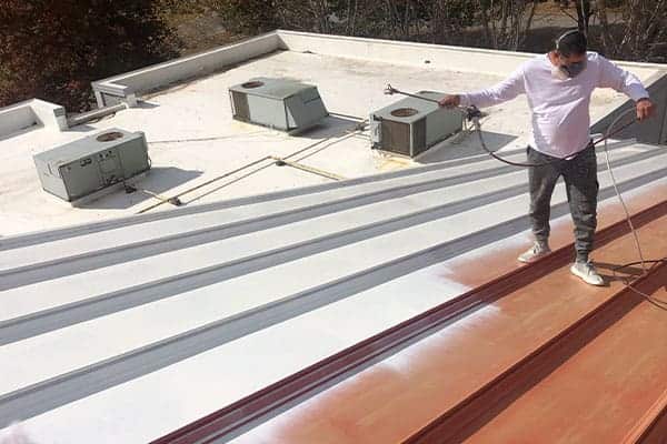Roof coating application in progress — Volunteer fire station